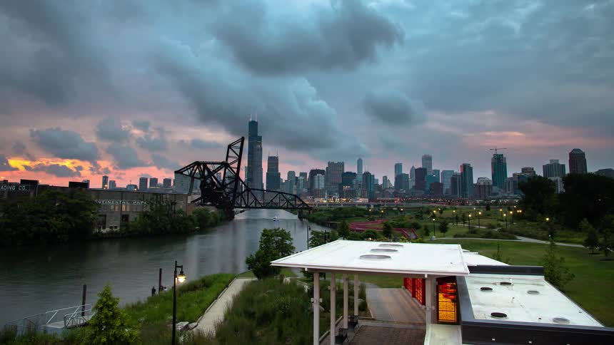 A stunning timelapse captures the Chicago skyline from Ping Tom Memorial Park as boats travel the river during a dramatic sunset that fades into a vibrant city night