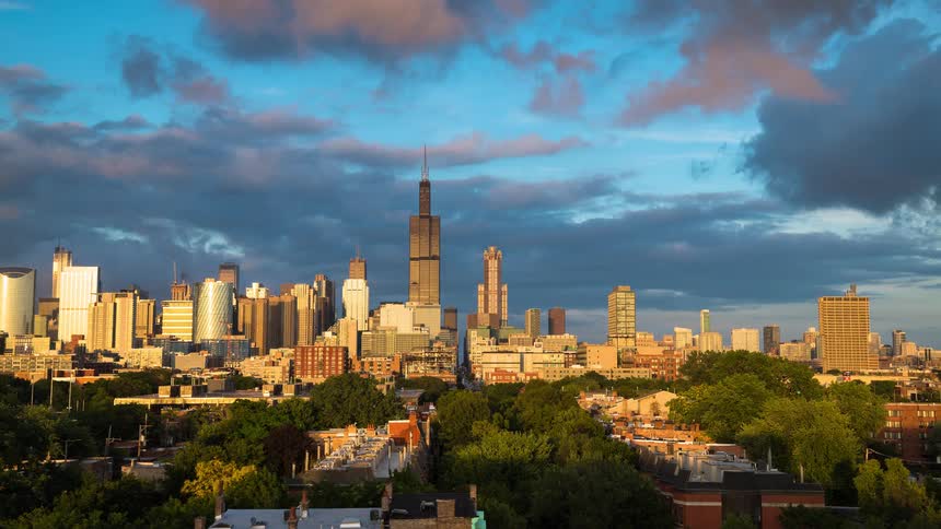 A golden sunset timelapse over the Chicago skyline, featuring the Willis Tower, as pink and purple clouds roll by