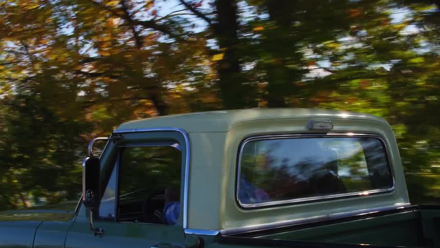 Truck drives down a tree lined country road