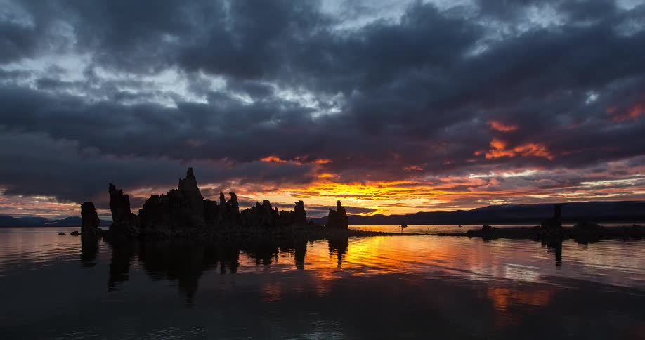 A breathtaking timelapse of a fiery sunrise over the Tufa towers at Mono Lake, with clouds and colors reflecting in the water