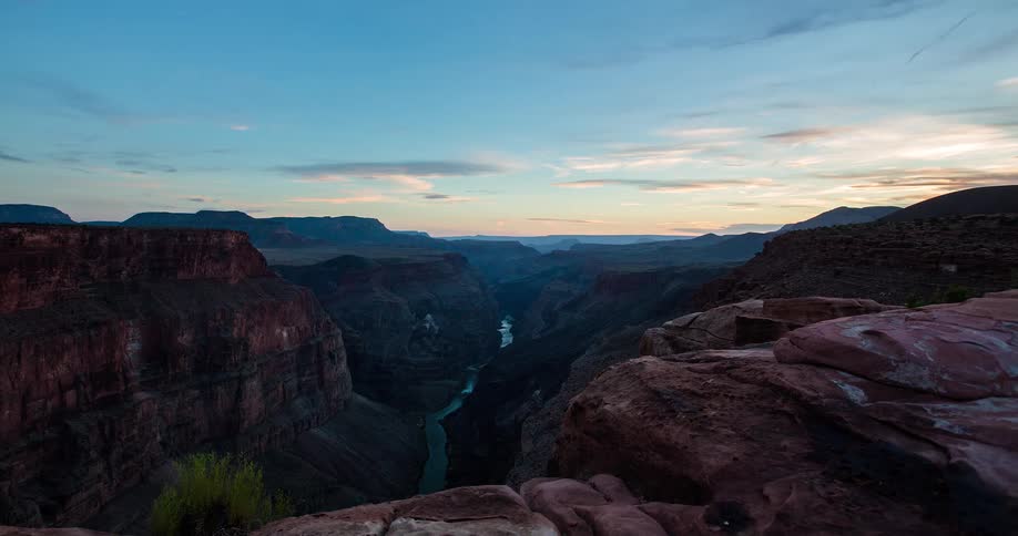An epic timelapse shows the sun setting over the majestic Grand Canyon, with the Colorado River winding below as twilight descends