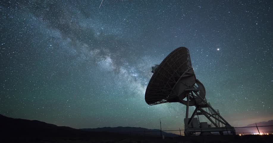 A stunning timelapse of the Milky Way galaxy moving across the starry night sky behind a large radio telescope antenna