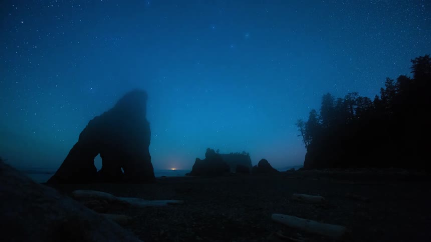 A stunning night-to-day timelapse shows stars moving over coastal sea stacks before thick fog rolls in, obscuring the landscape as dawn breaks