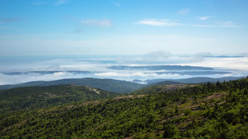 Breathtaking timelapse of morning fog and clouds rolling over the lush green mountains and islands of Acadia National Park