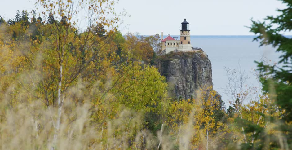 The iconic Split Rock Lighthouse stands on a cliff overlooking Lake Superior, surrounded by vibrant autumn foliage