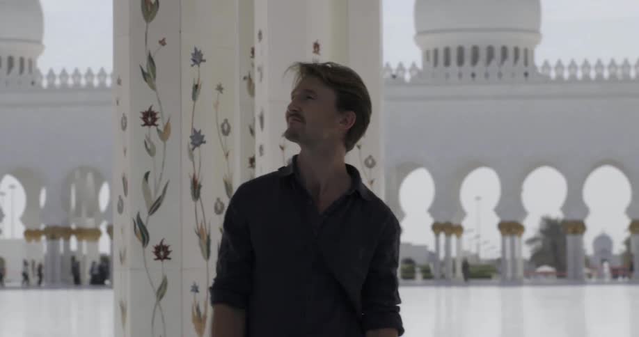 Man walks through an ornate white building
