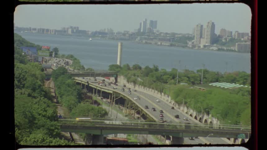 Vintage film footage zooms in on the Henry Hudson Parkway in New York City on a bright summer day