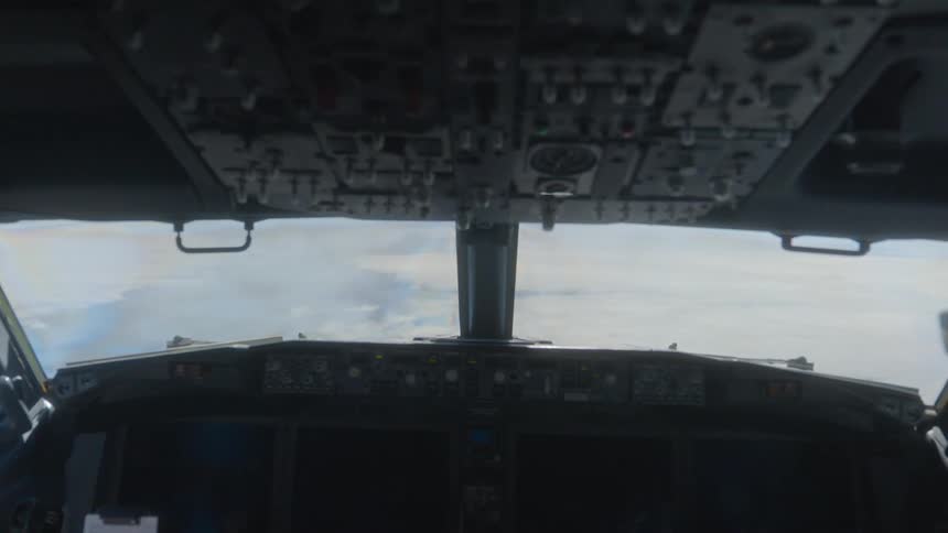Static point-of-view from inside a commercial airliner's cockpit looking forward at the cloudy sky
