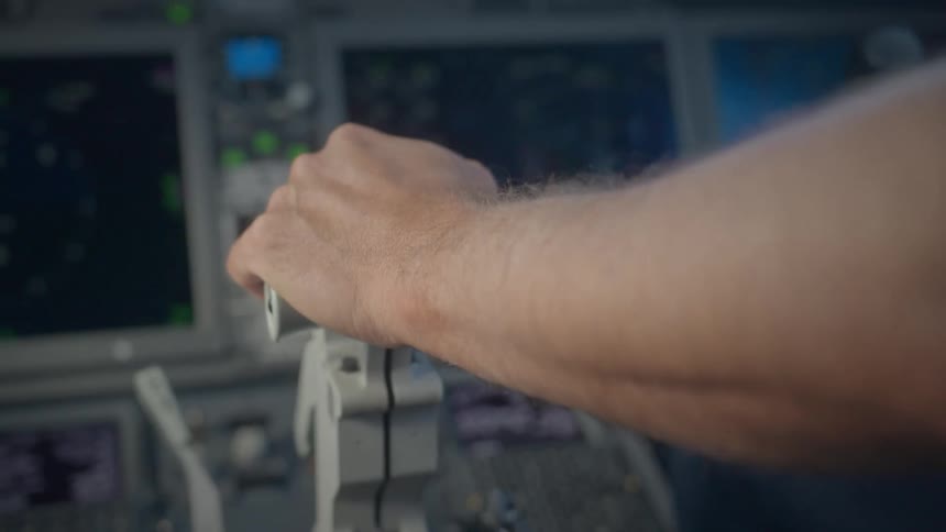 Close-up of a pilot's hand resting on the throttle lever inside a modern airplane cockpit