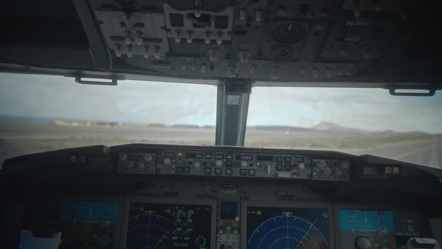Cockpit view of a commercial airliner accelerating down the runway for takeoff