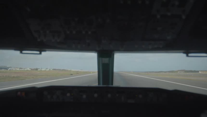 A point-of-view shot from an airplane cockpit taxiing down the runway at an airport
