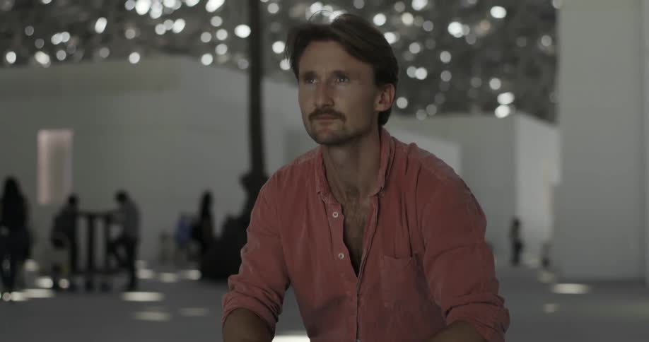 A man is sitting down holding a camera