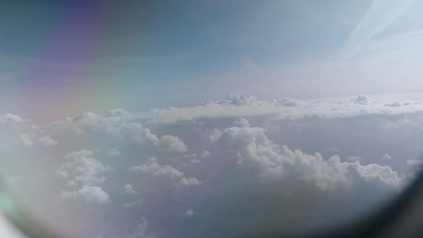 A dreamy aerial view reveals a vast sea of clouds from an airplane window