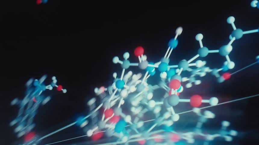 A macro view of a scientific animation showing molecules bonding and forming a complex chemical structure