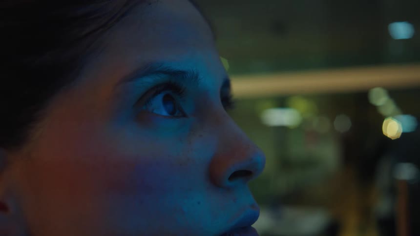An extreme close-up of a young woman's face with wide eyes, mesmerized by what she is seeing