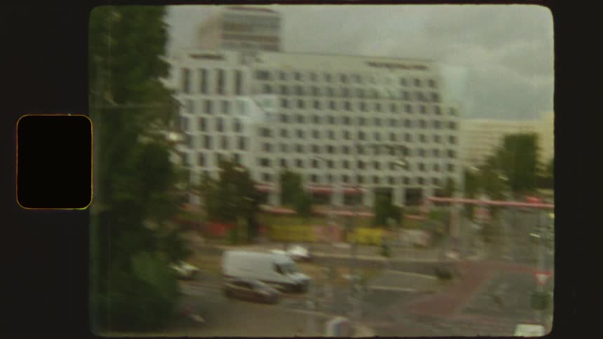 Nostalgic Super 8mm footage of Berlin's cityscape, showing the iconic TV Tower and city buildings from a moving vehicle