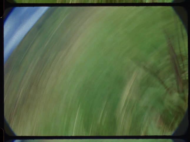 Vintage Super 8 footage captures the chaotic, dizzying point-of-view of tumbling down a lush green hillside