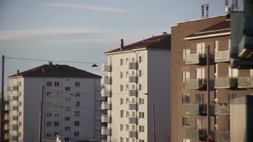 A static shot of modern white and brick apartment buildings in an urban residential area