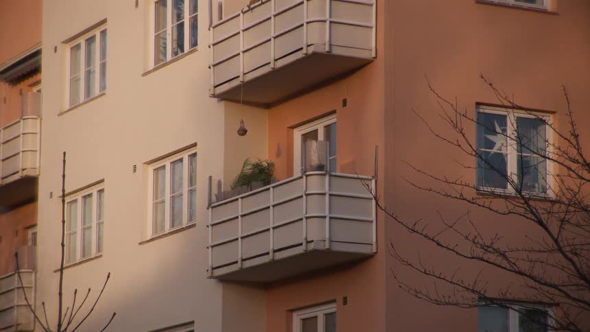 A slow zoom out of a colorful apartment building exterior with balconies and windows