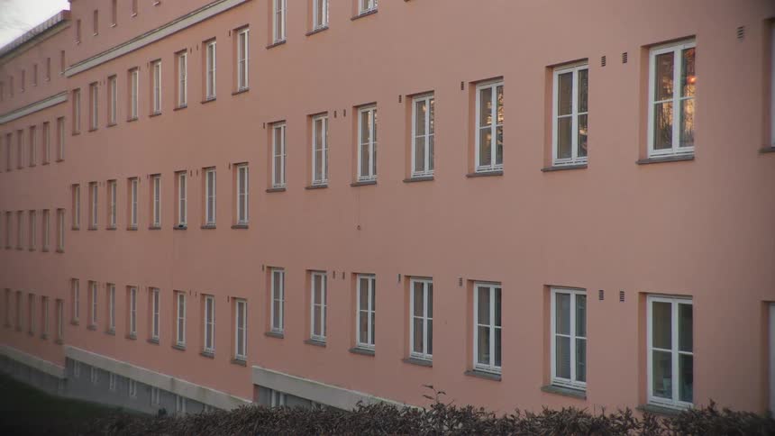 Exterior of a pink multi-story building with uniform windows