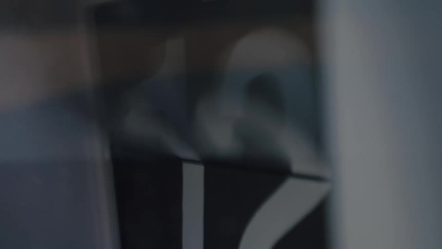 A minimalist black and white flip clock rapidly counts the seconds in a blurry close-up shot