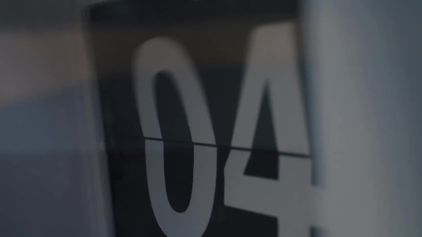 Time flies by in a fast-forward close-up of a mechanical flip clock's changing numbers