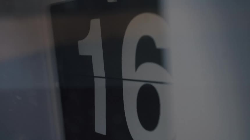 A close-up of a retro mechanical flip clock as the numbers count up quickly in a time-lapse