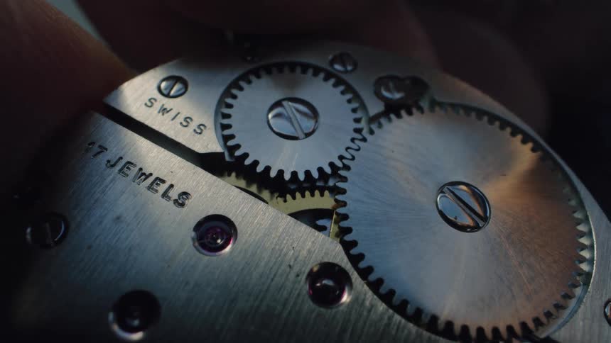 The inner workings of a classic Swiss watch show intricate gears and jewels in precise motion