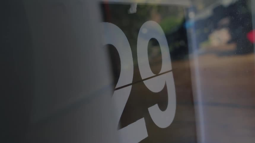 Close-up of a vintage flip clock changing from the number 28 to 29