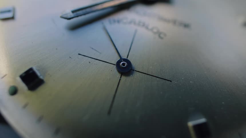 A macro close-up captures the steady ticking of the second hand on a classic analog watch face