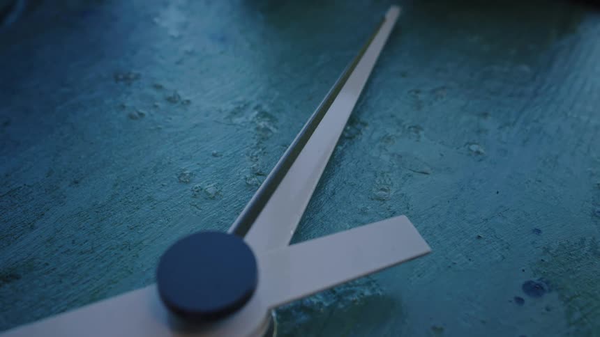 The thin second hand on a modern clock sweeps steadily forward, marking the passage of time in an extreme close-up shot