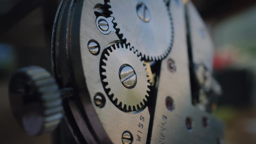 Detailed macro shot of the spinning gears and cogs inside an antique Swiss watch