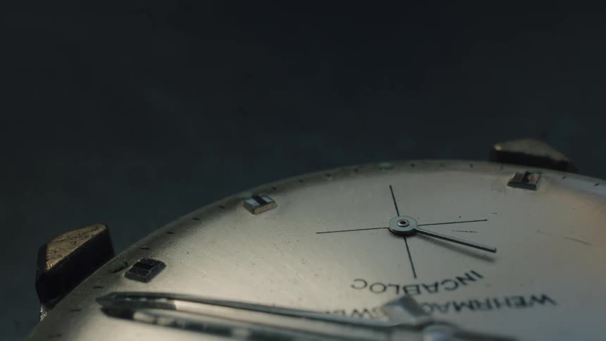 A macro close-up of a vintage analog watch face with the second hand ticking, representing the inexorable passage of time
