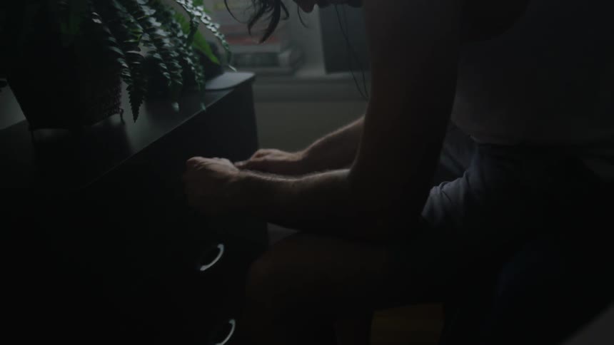 A man gestures his hands while listening to music through headphones