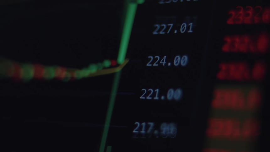 A macro shot of a digital screen reveals a rapidly changing stock market graph, with prices fluctuating and a green line trending upwards