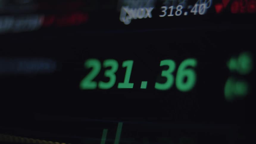 Green numbers fluctuate rapidly on a dark stock market ticker screen, displaying real-time financial trading data