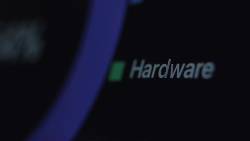 An extreme close-up shot reveals the word 'Hardware' on a dark computer screen with out-of-focus blue graphics