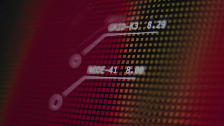 A close-up of a futuristic digital display shows grid and node data on a red and yellow pixelated screen