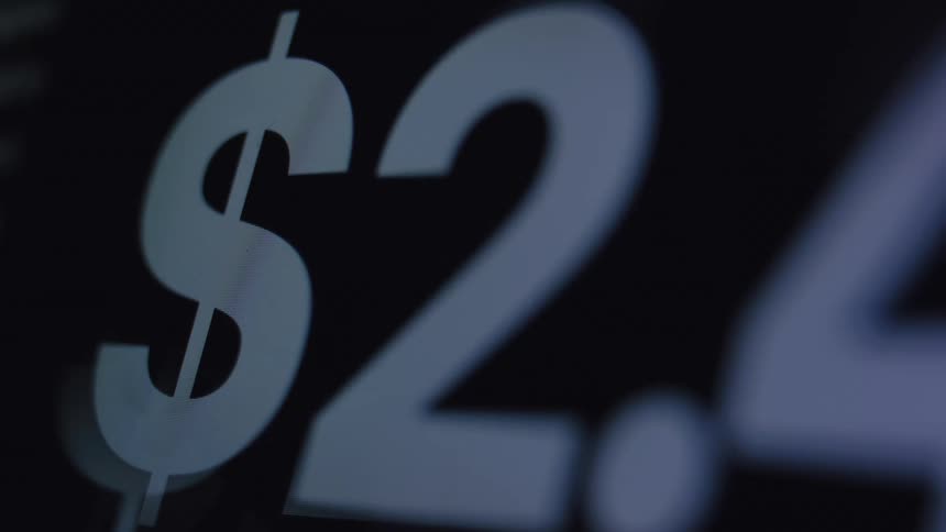 A close-up macro shot of a digital screen displaying a rapidly increasing dollar amount