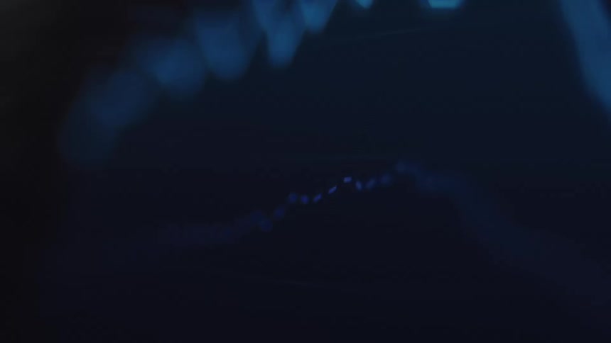 A fluctuating blue digital chart line trends downwards in a dark, abstract macro shot