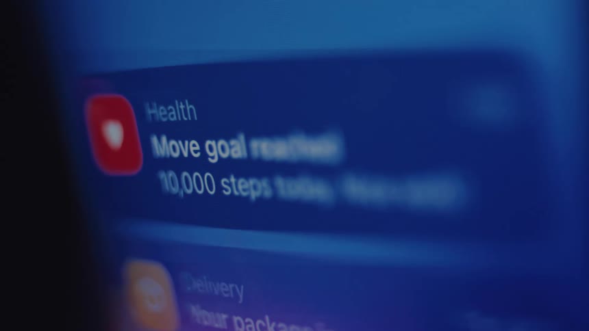 A close-up shot of a smartphone screen showing push notifications for package delivery and health app goals