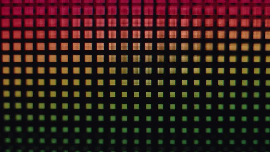 Macro close-up shot of the colorful pixels on a digital screen forming a vibrant gradient