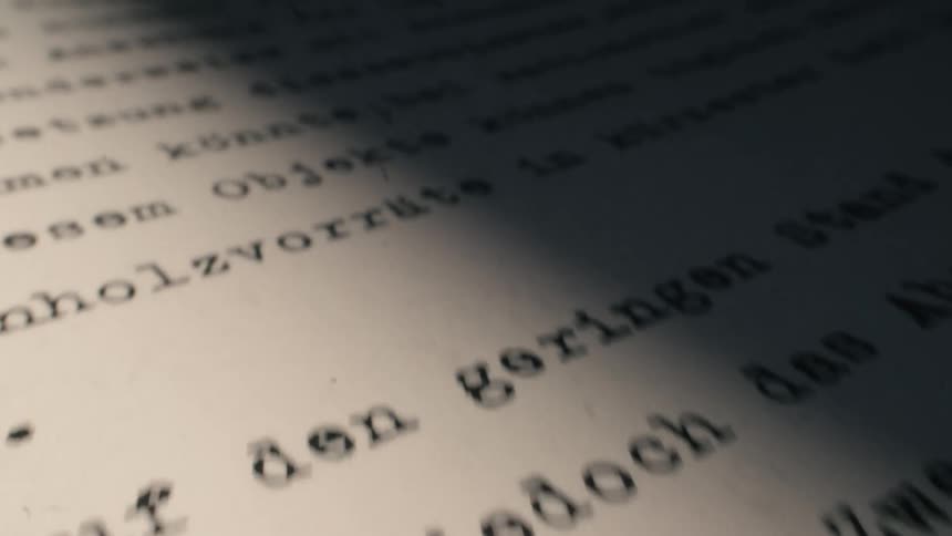 A dramatic close-up pan across an old typewritten document in German with a vintage film effect