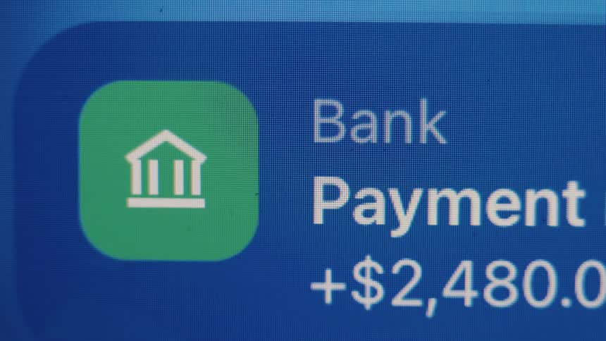 Macro close-up of a bank payment notification for over two thousand dollars appearing on a digital screen
