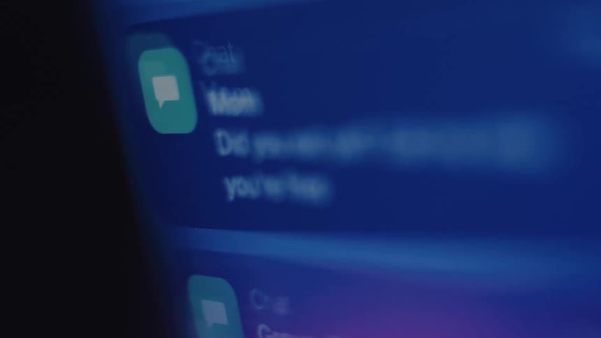 A close-up, rack focus shot of a smartphone screen receiving a caring text message notification from a mother at night