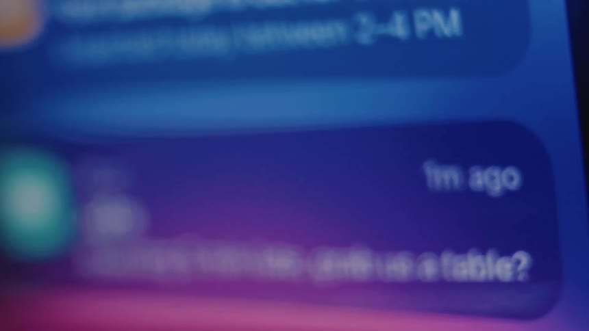 An extreme close-up, out-of-focus shot of a smartphone screen scrolling through a constant stream of notifications from various apps