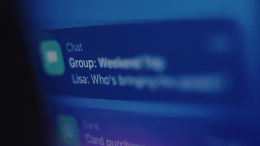 A 'Weekend Trip' group chat notification pops up on a smartphone screen in the dark