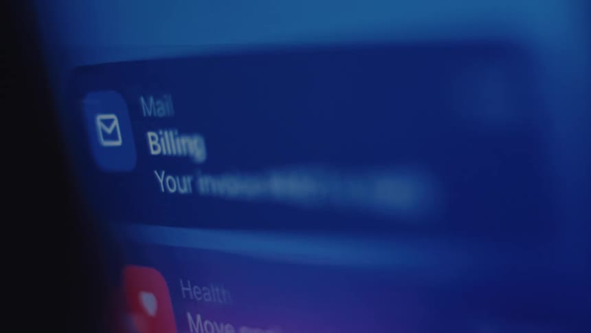 A close-up, blurry view of a smartphone screen shows a stream of notifications for health goals and financial billing