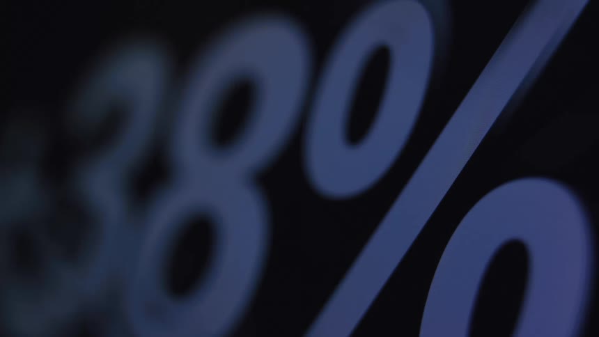 A digital percentage counter rapidly increases on a dark screen in a macro close-up shot
