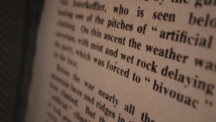 A slow, soft-focus pan over the text printed on the aged pages of a vintage book